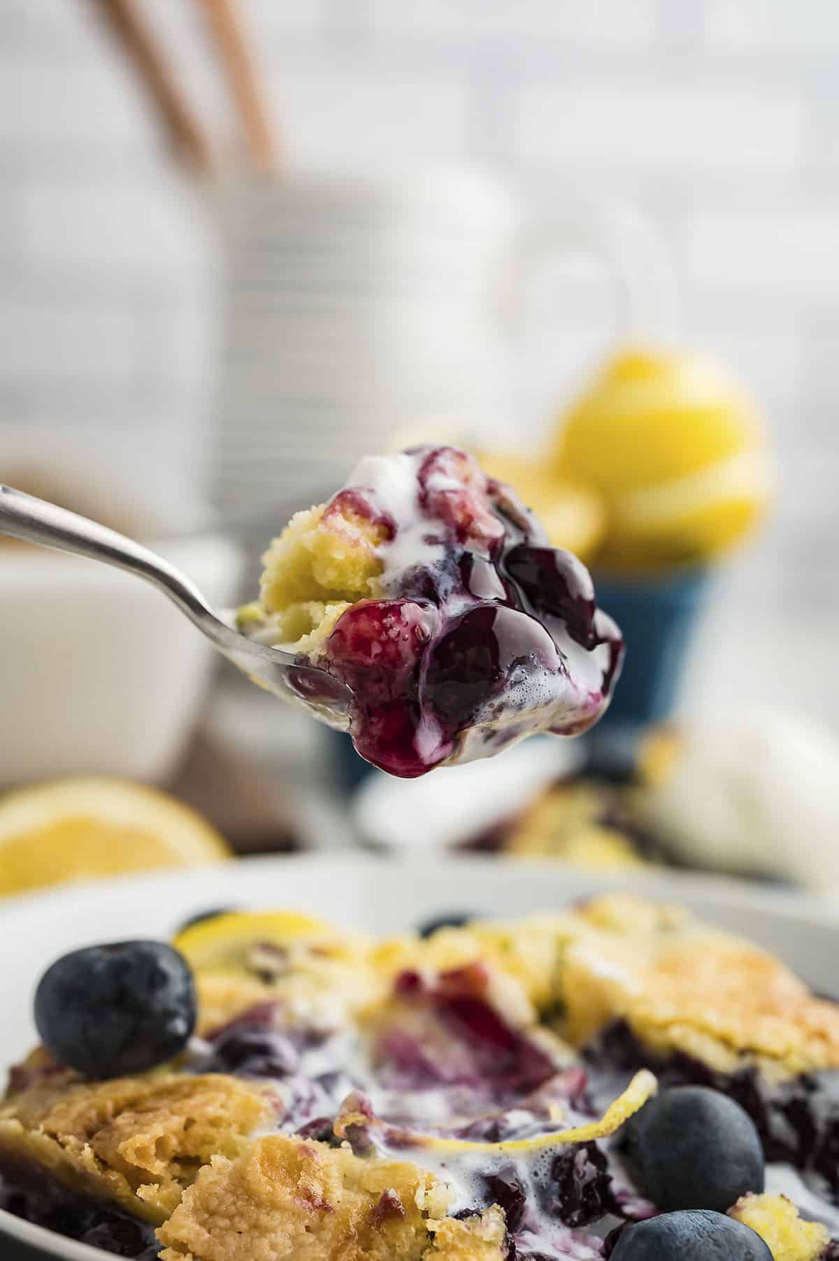 Spoonful of blueberry lemon dump cake with vanilla ice cream.