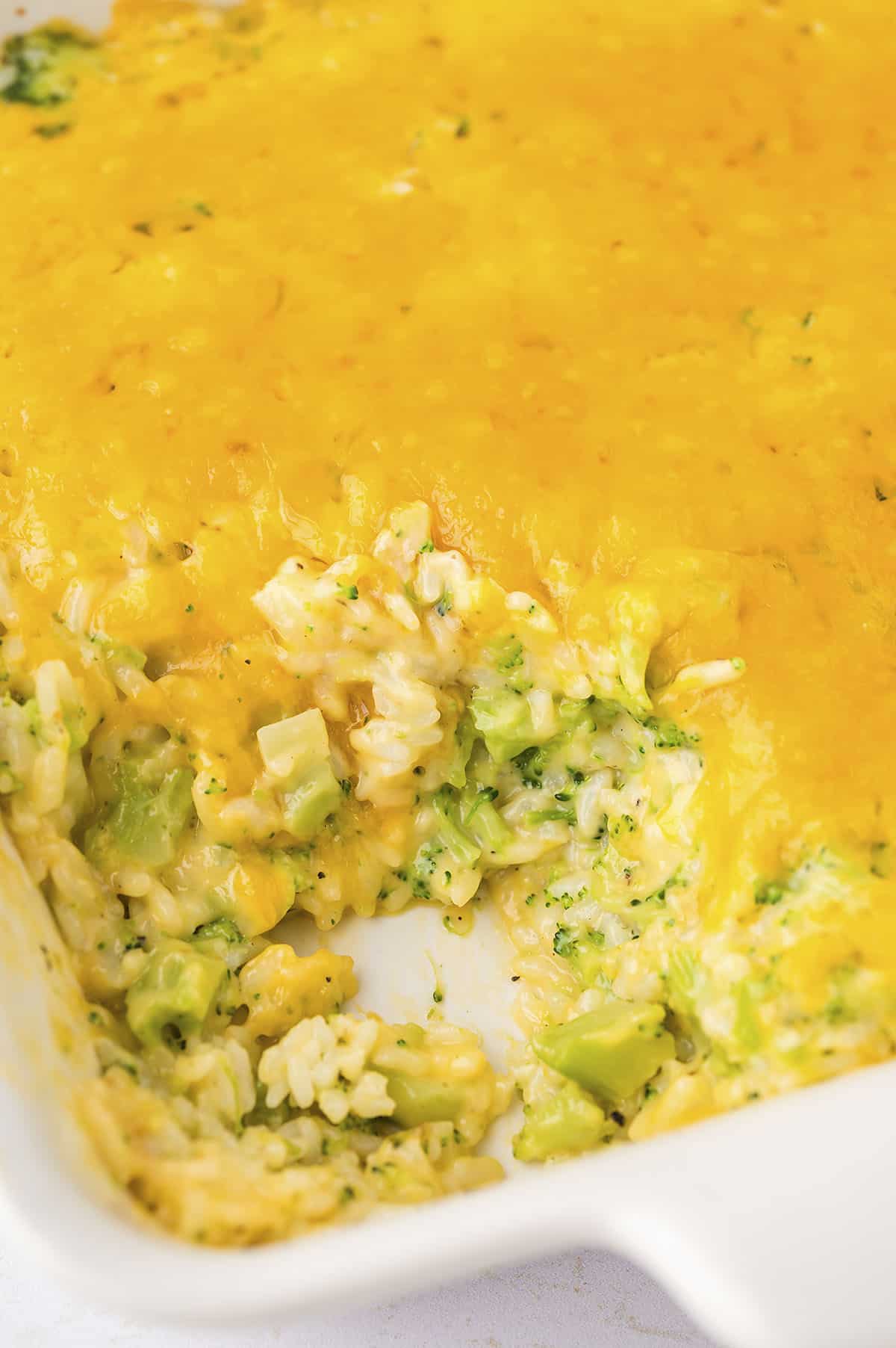 White baking dish full of cheesy broccoli rice casserole.