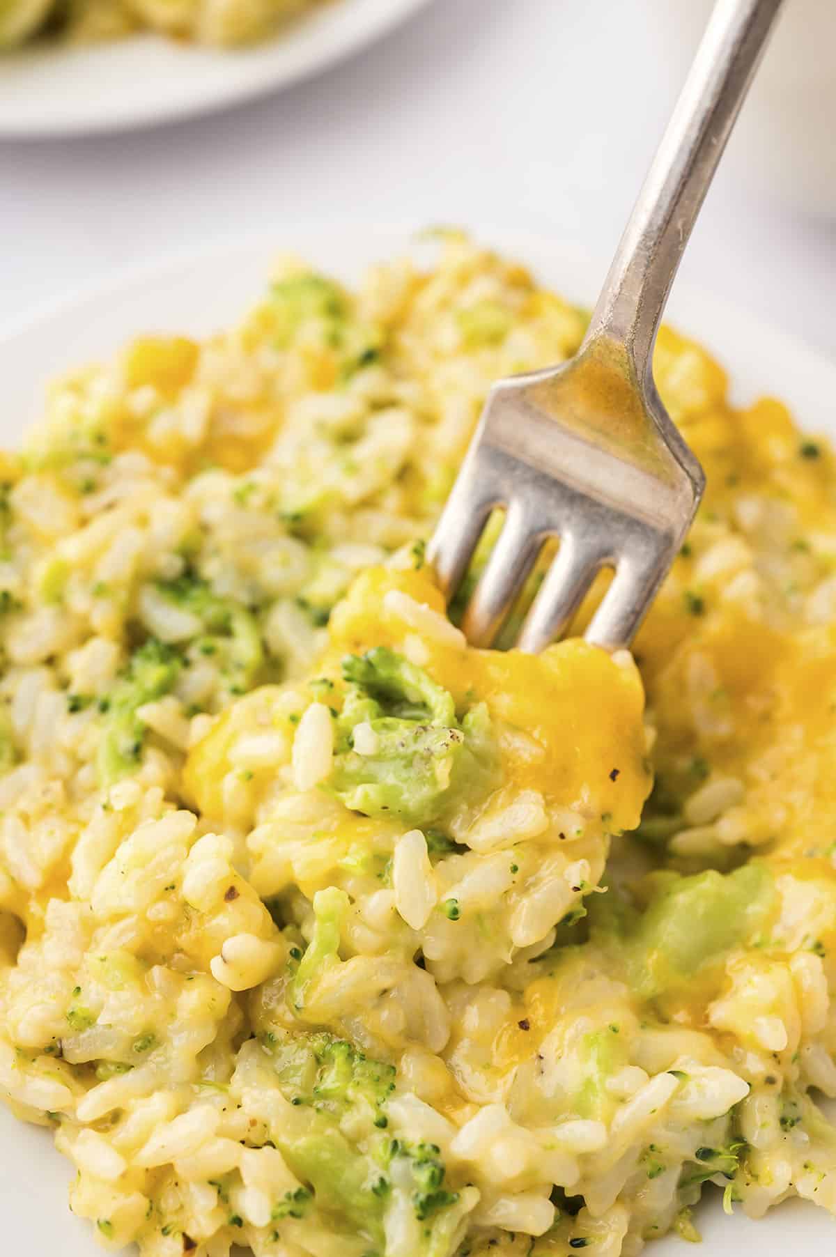 Fork full of broccoli cheese rice casserole.