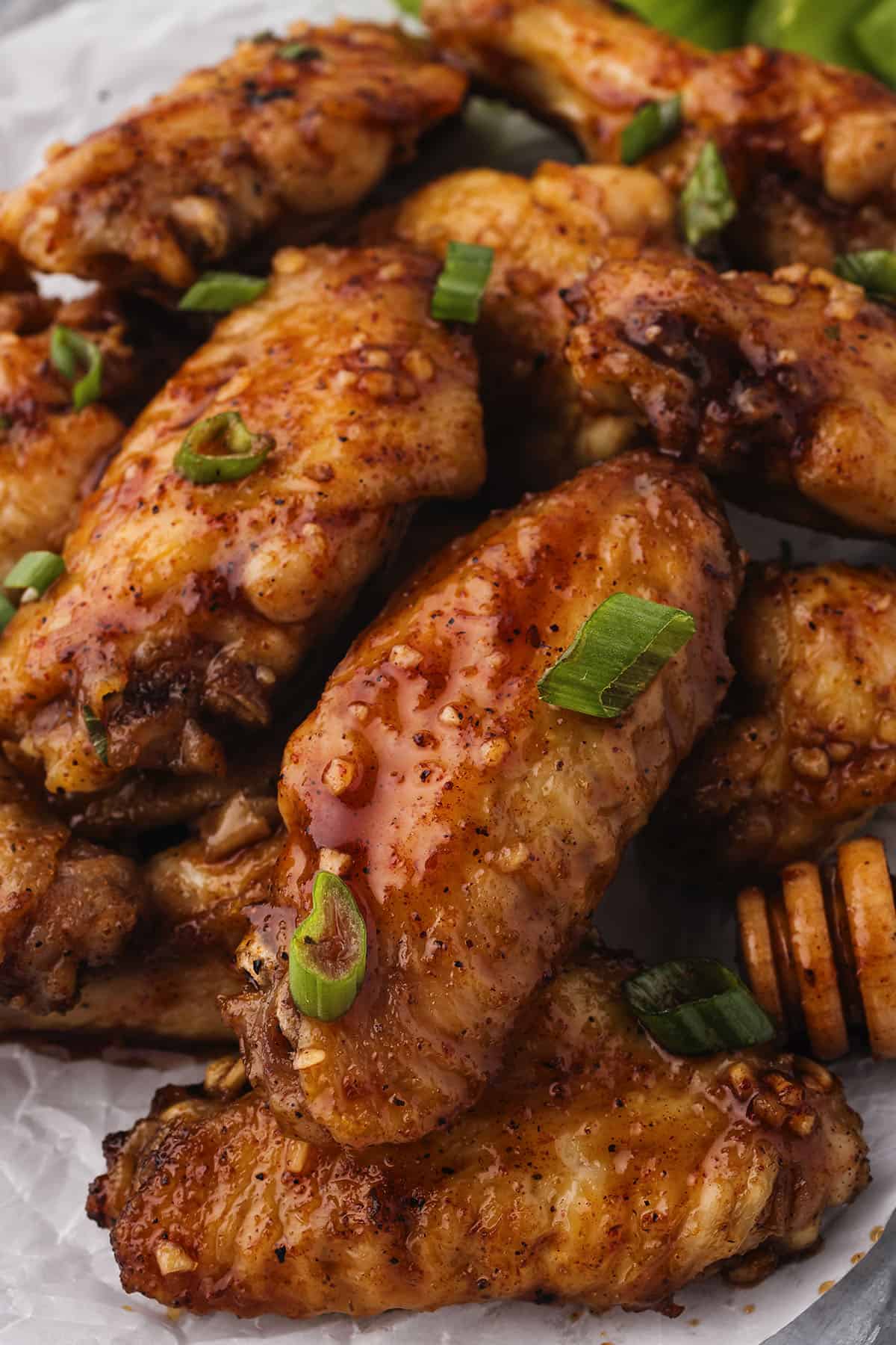 Close up of hot honey chicken wings piled on platter.