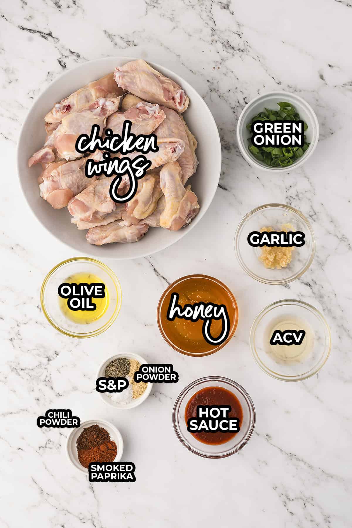 Ingredients for honey hot wings recipe laid out on counter top in individual containers.