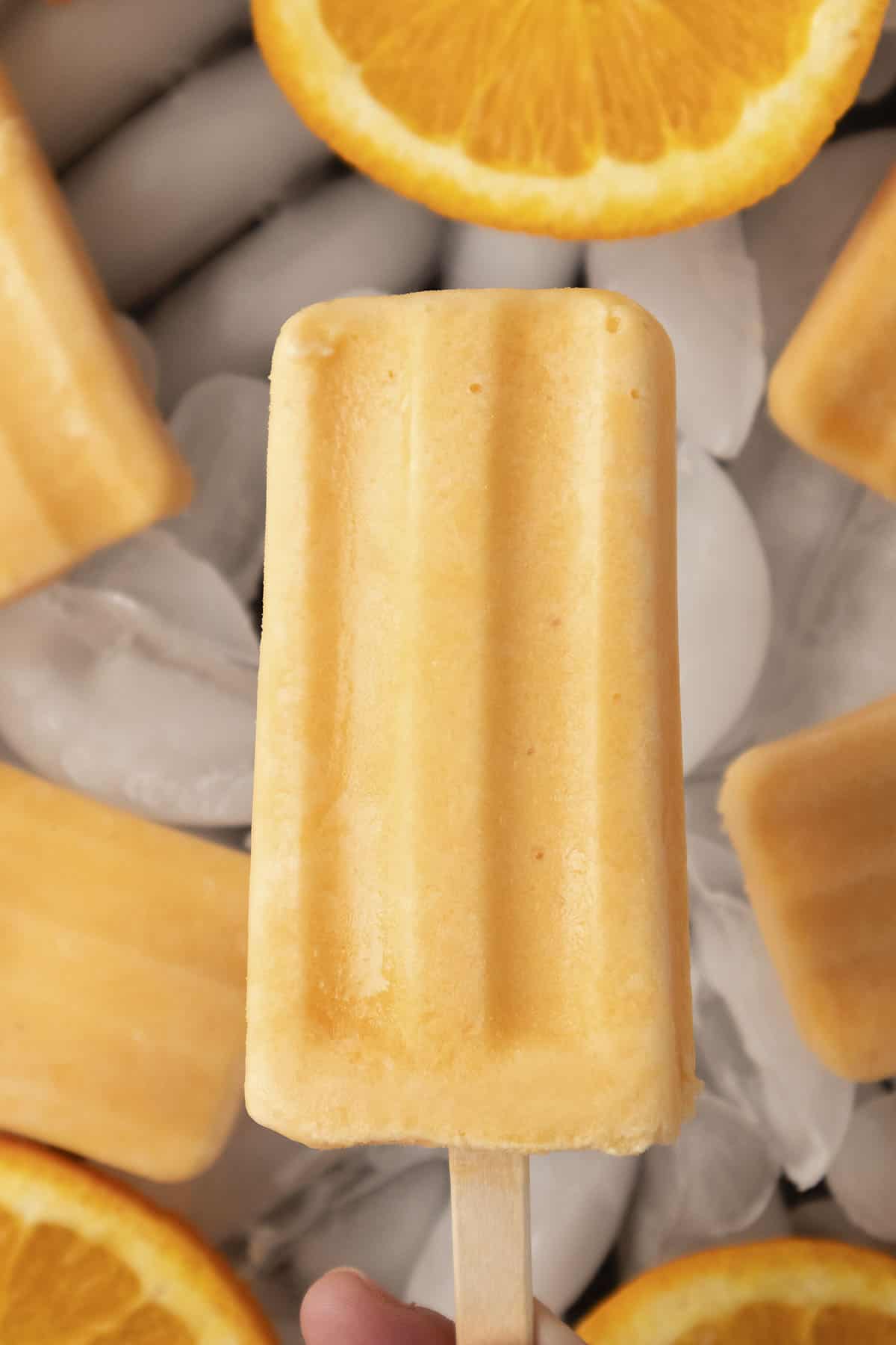 Hand holding up an orange creamsicle.