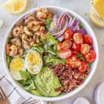 White bowl full of grilled shrimp salad.