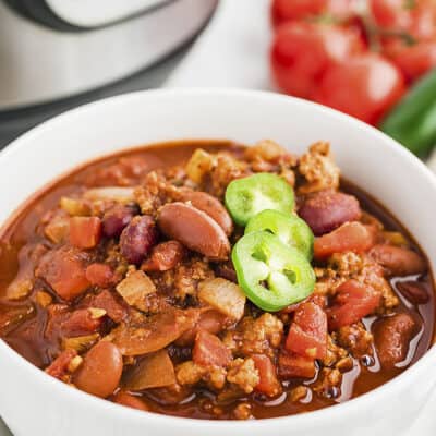 Turkey chili in white bowl in front of Instant Pot.