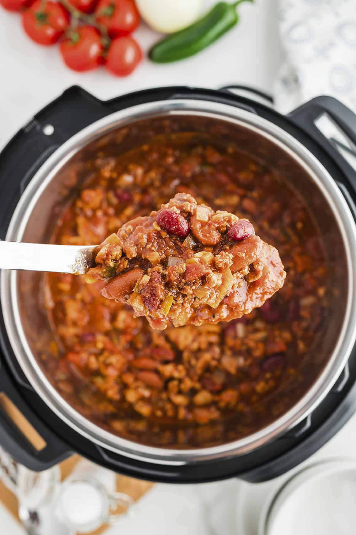 Turkey chili on spoon over the Instant Pot.