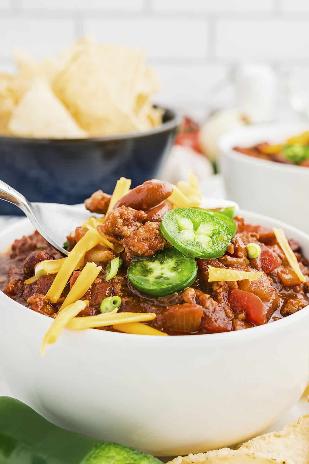 Spoonful of turkey chili in white bowl.