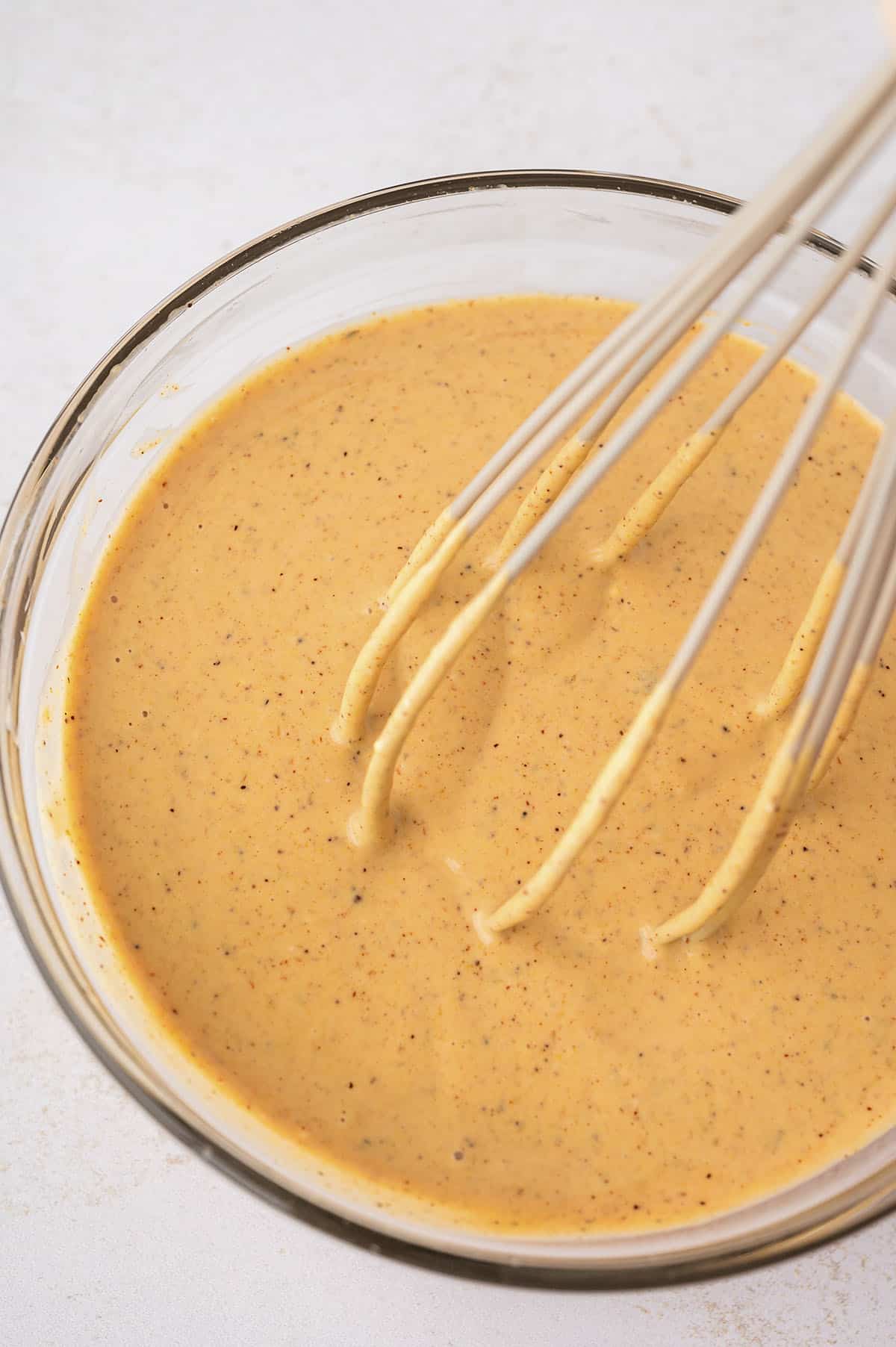 Smash burger sauce in glass mixing bowl with whisk.
