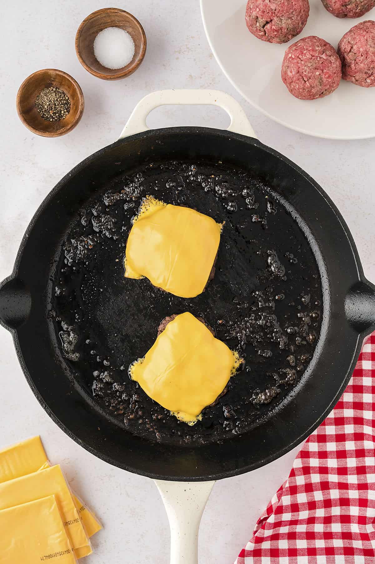 Smash burgers with cheese on top.