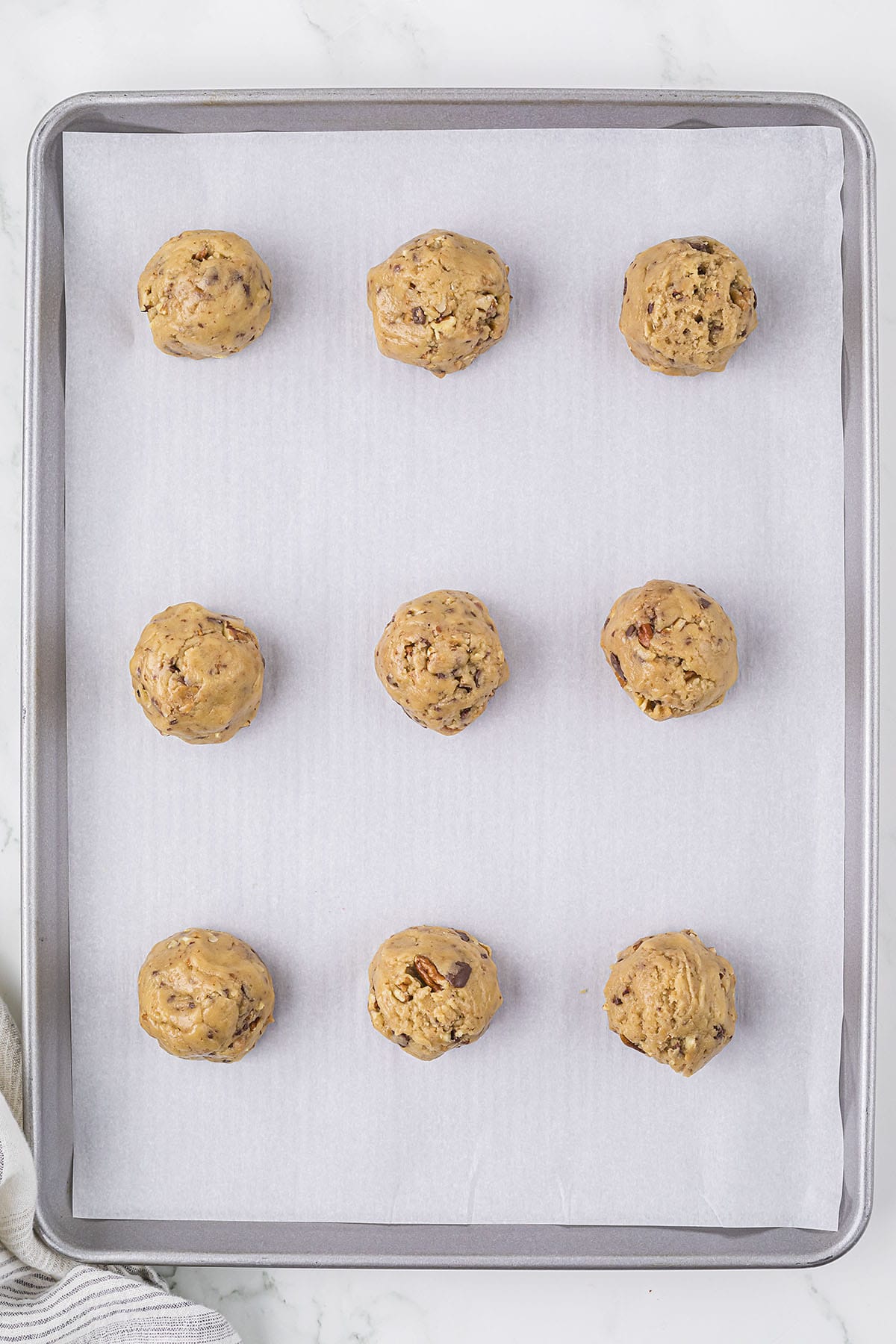 Cookie dough balls on baking sheet.