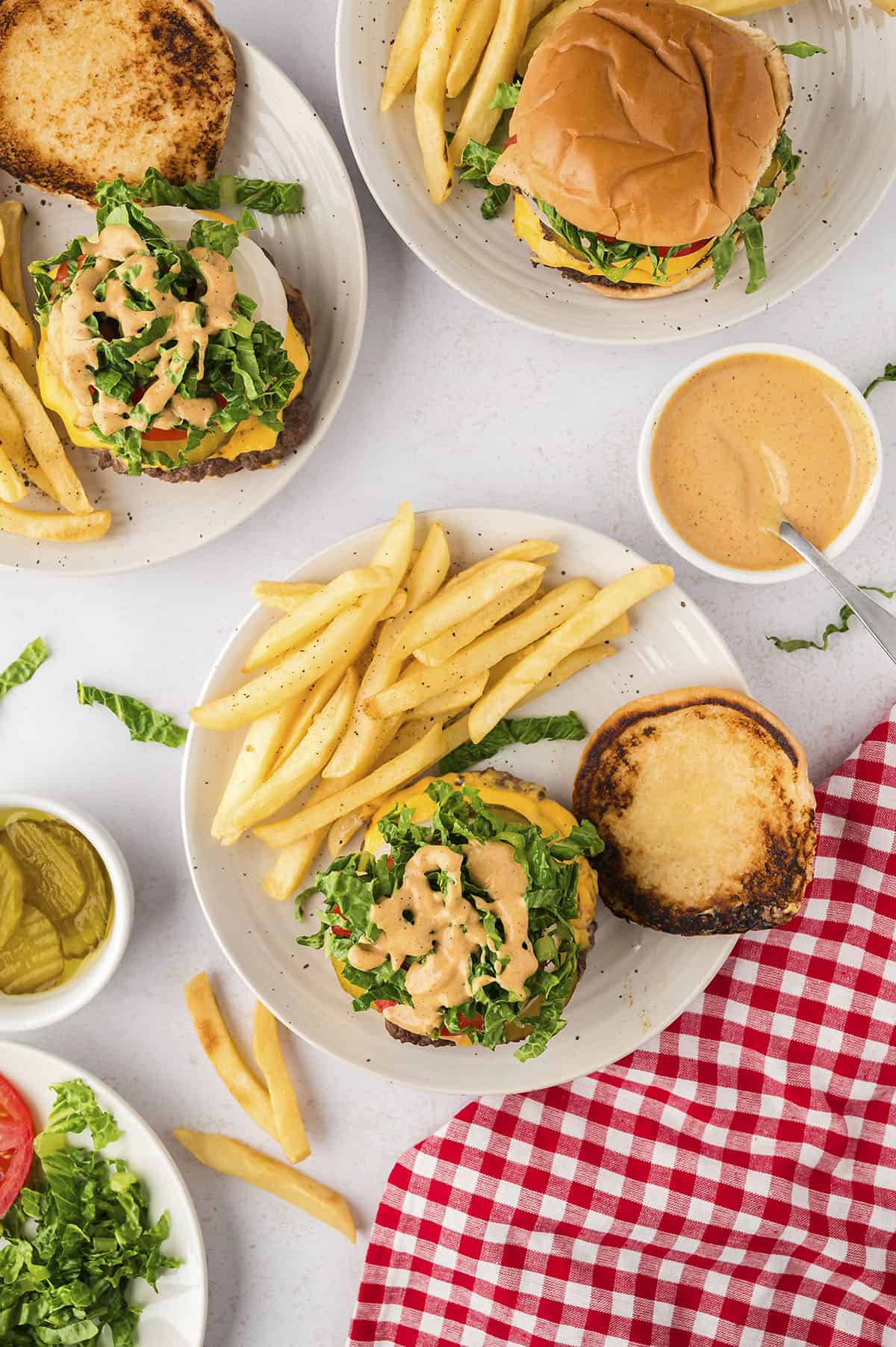 Smash burger on plate with toasted bun and french fries.