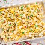 Pan full of white chocolate popcorn with Christmas sprinkles.