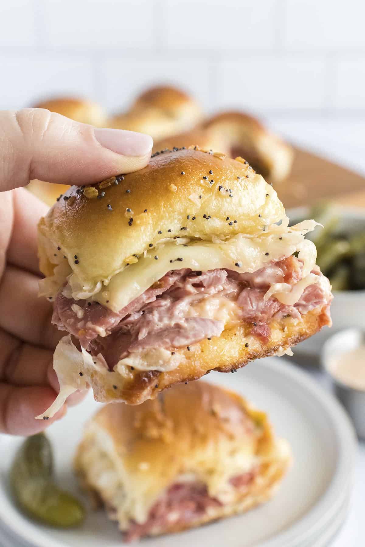 Hand holding a reuben slider.