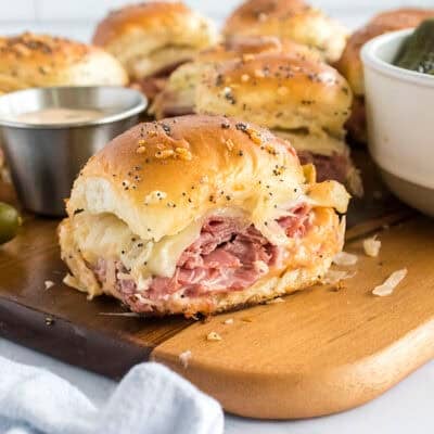Reuben slider on wooden board.