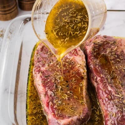 Marinade being poured over steak.