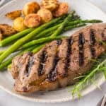 Grilled steak on plate with asparagus and potatoes.