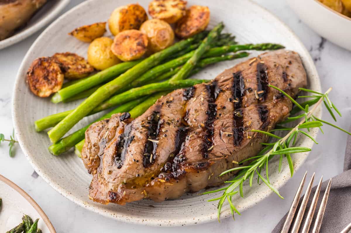 Grilled steak on plate with asparagus and potatoes.