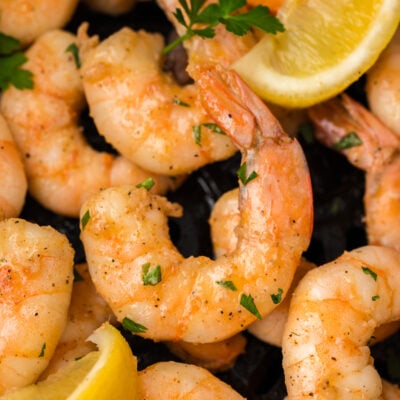 Cajun buttered shrimp in air fryer basket.