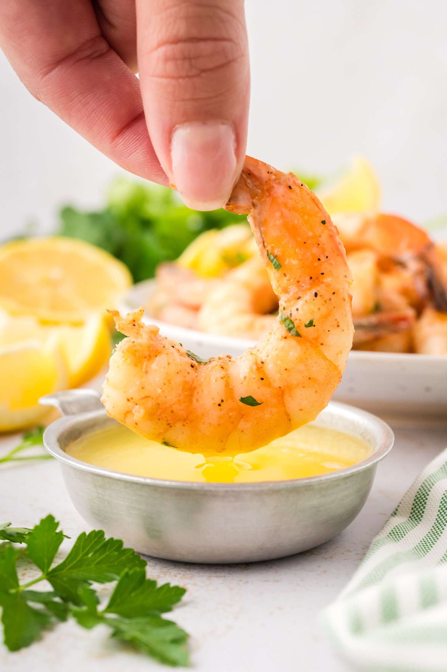 Cajun shrimp being dipped in lemon butter sauce.