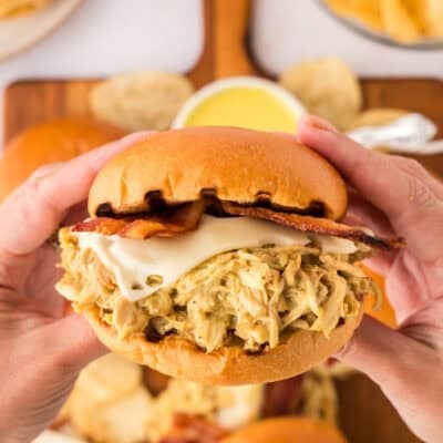 Hand holding a crockpot honey mustard chicken sandwich.