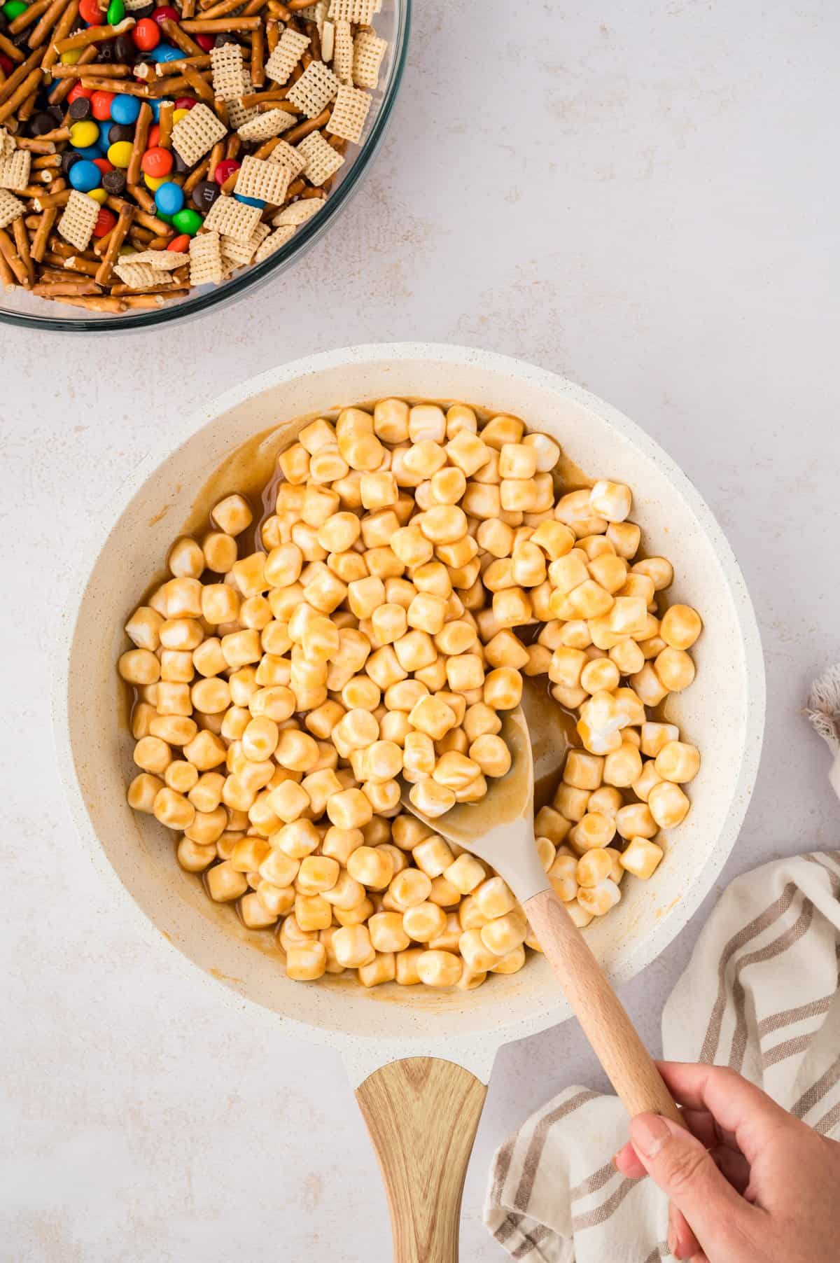 Marshmallows and peanut butter melting in pot.