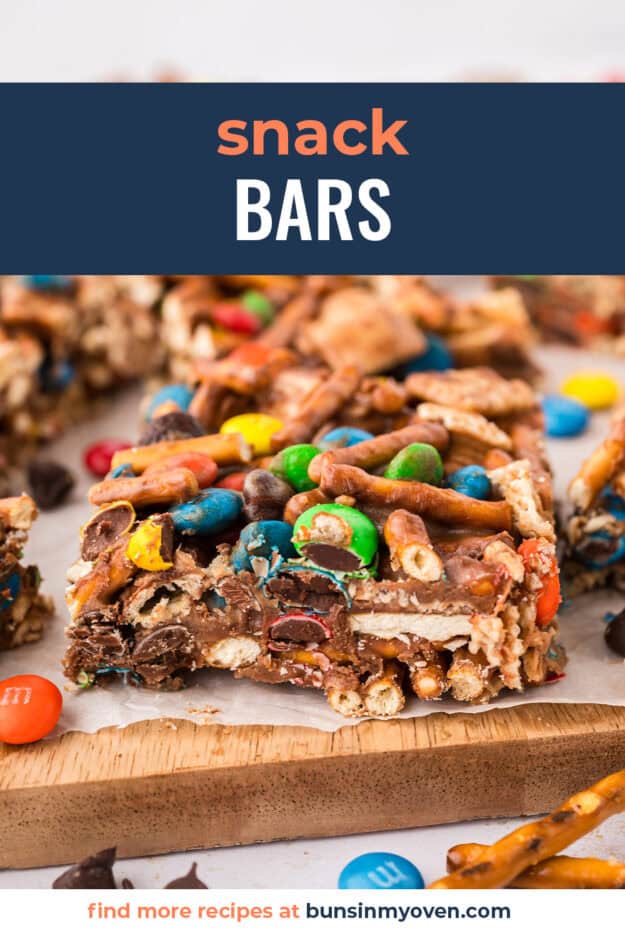 Snack mix bars on wooden cutting board.