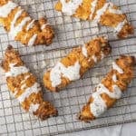 Crispy air fried buttermilk chicken tenders drizzled with ranch on cooling rack.
