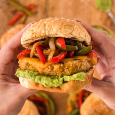 Hands holding a chicken fajita burger.