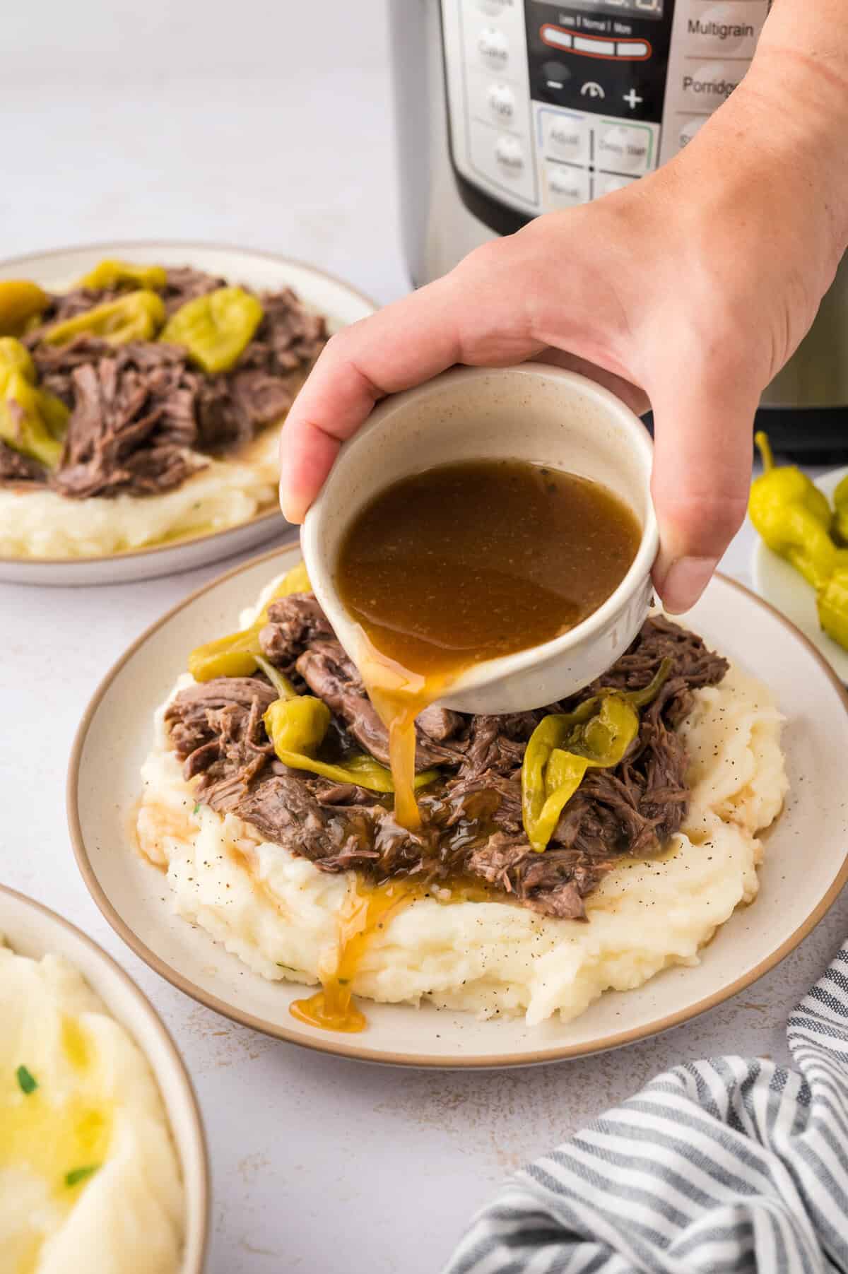Gravy being drizzled over Instant Pot Mississippi pot roast.