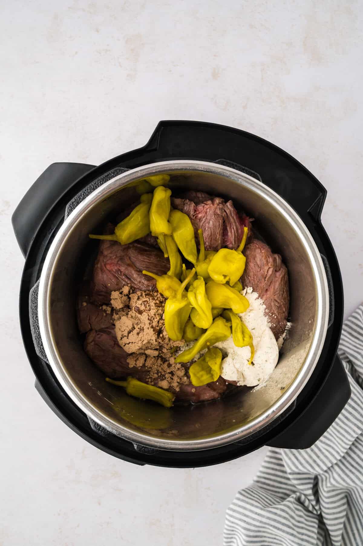 Beef, au jus, and pepepers in Instant Pot.