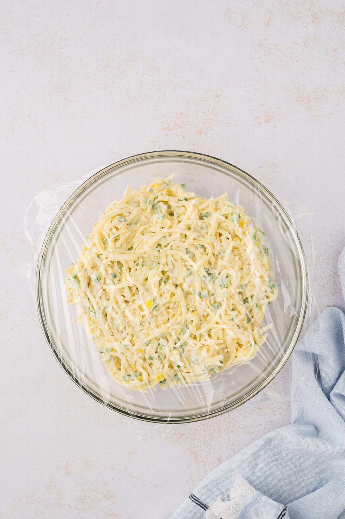 Covered cheese slaw in bowl.