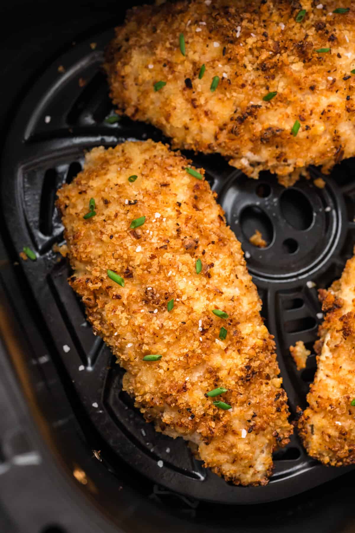 Crispy sour cream and onion chicken in air fryer basket.