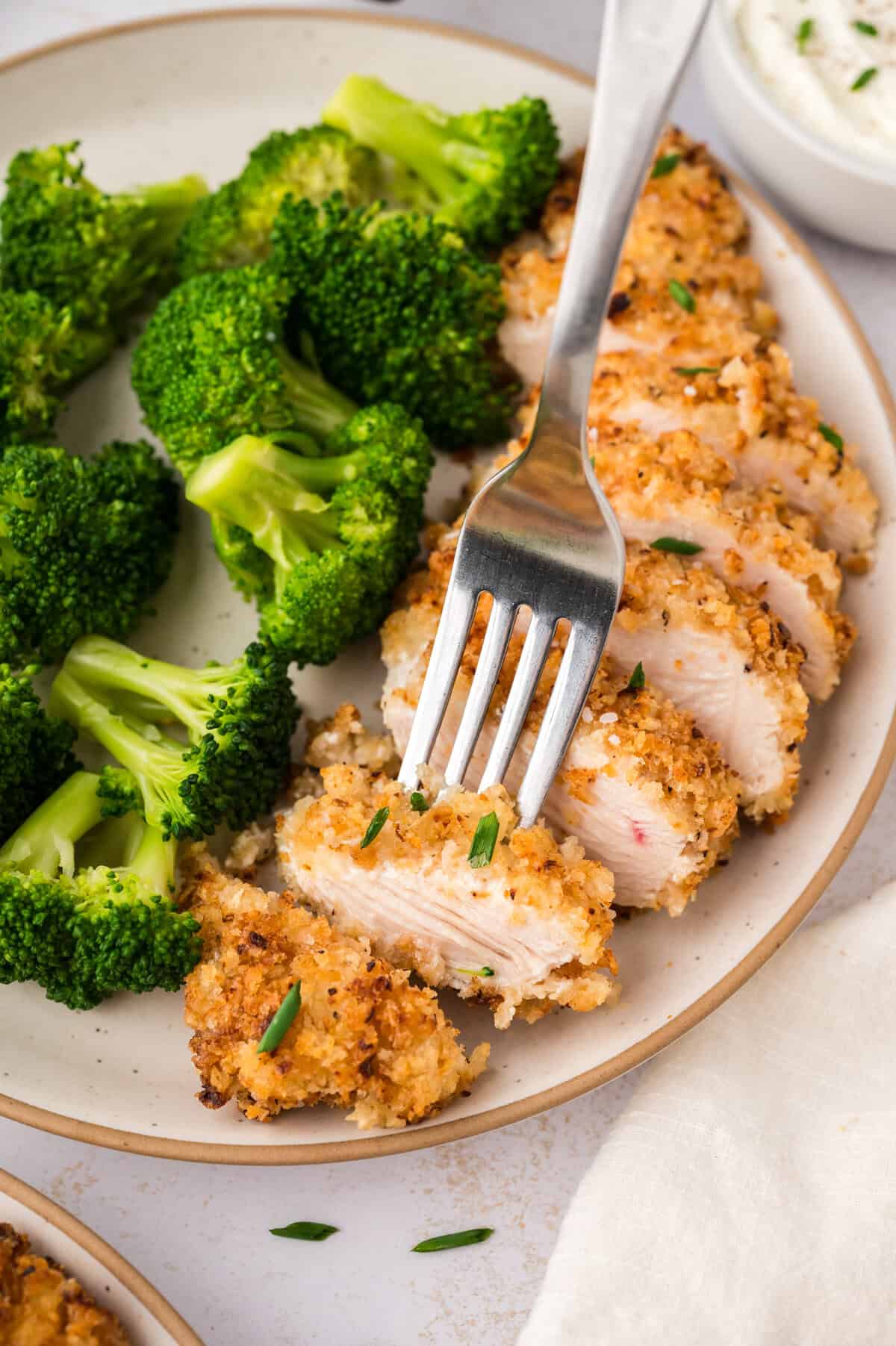 Sliced crispy sour cream and onion chicken on fork.