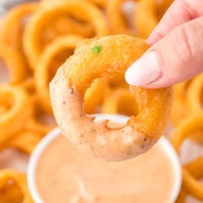 Crispy onion ring dunked in onion ring sauce.