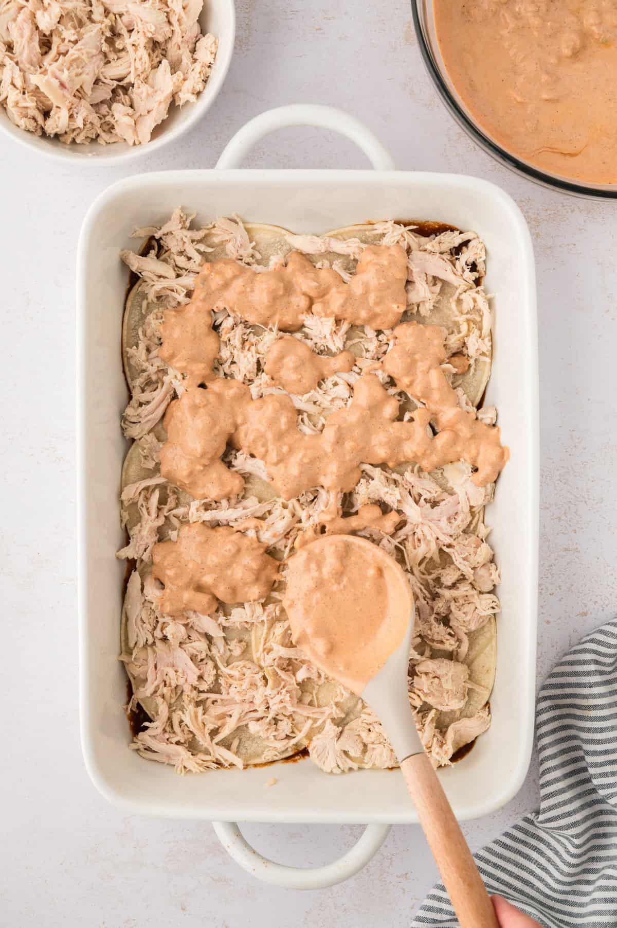 Layers of chicken and sauce in 9x13 dish.