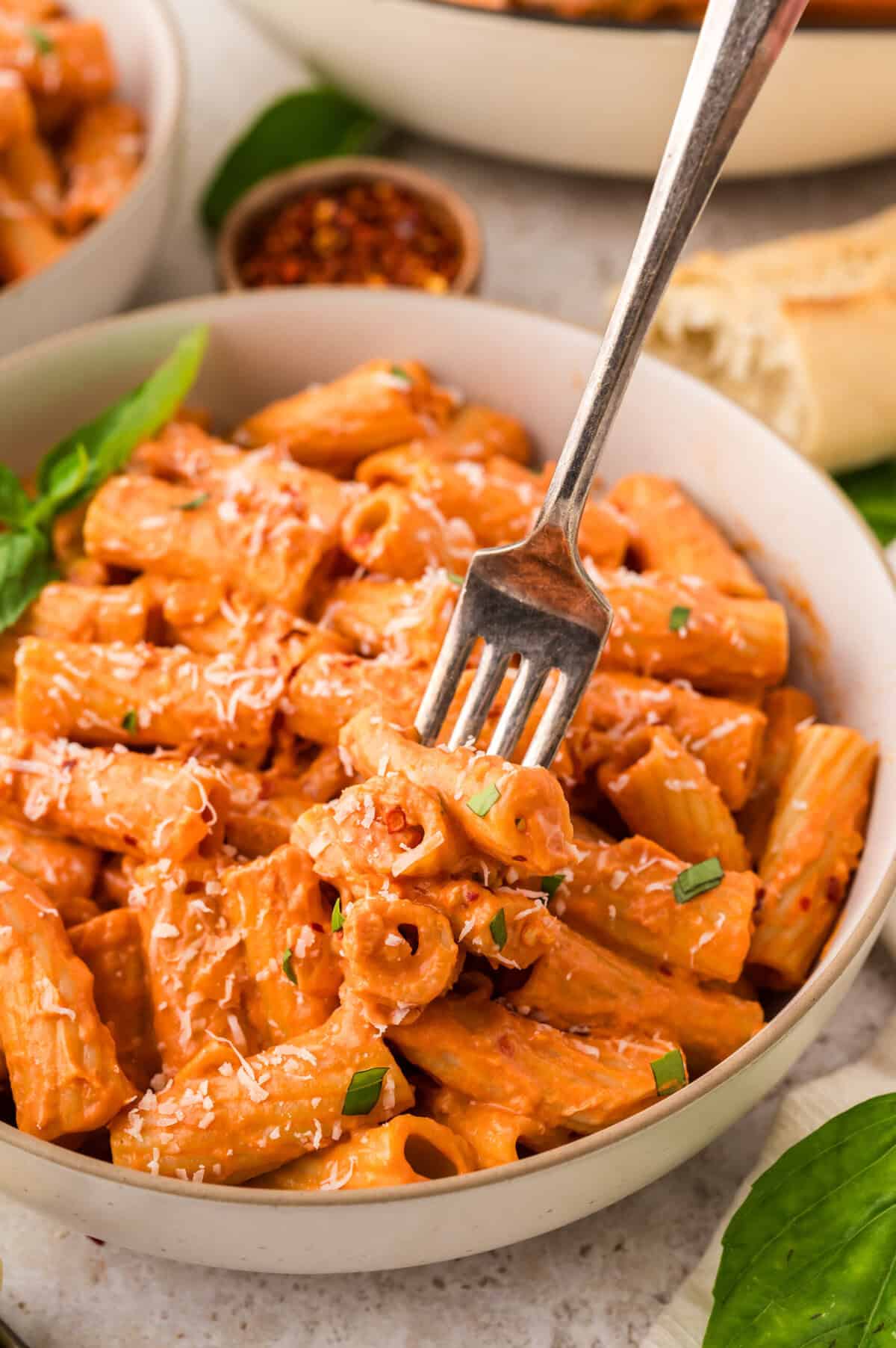 Not too spicy rigatoni in bowl with fork.