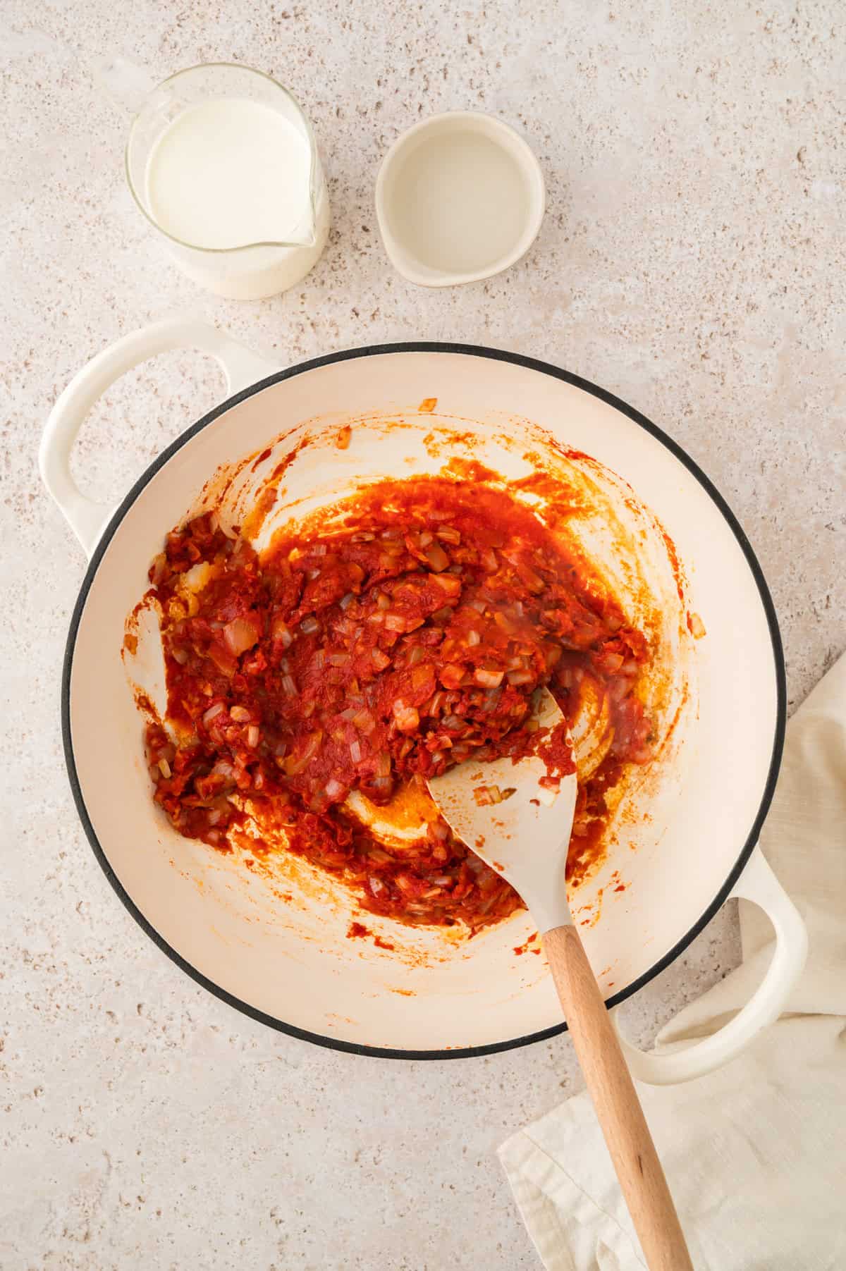 Tomato paste in skillet with garlic and onions.