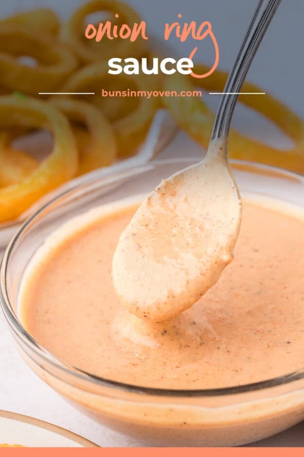 Sauce dripping off spoon in glass bowl.