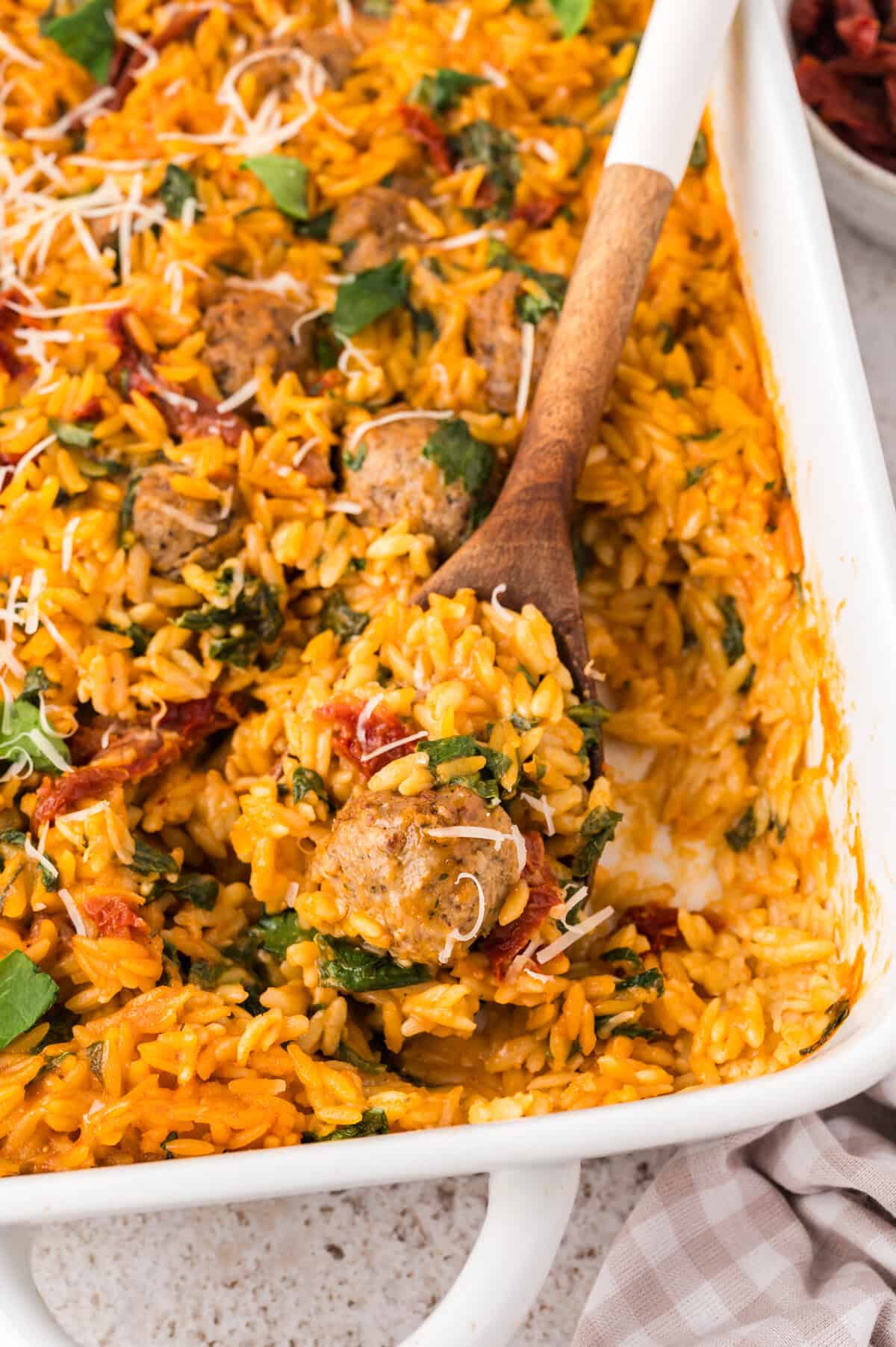 Creamy tomato baked orzo in white baking dish.