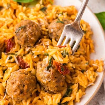 Baked orzo on plate with meatballs.