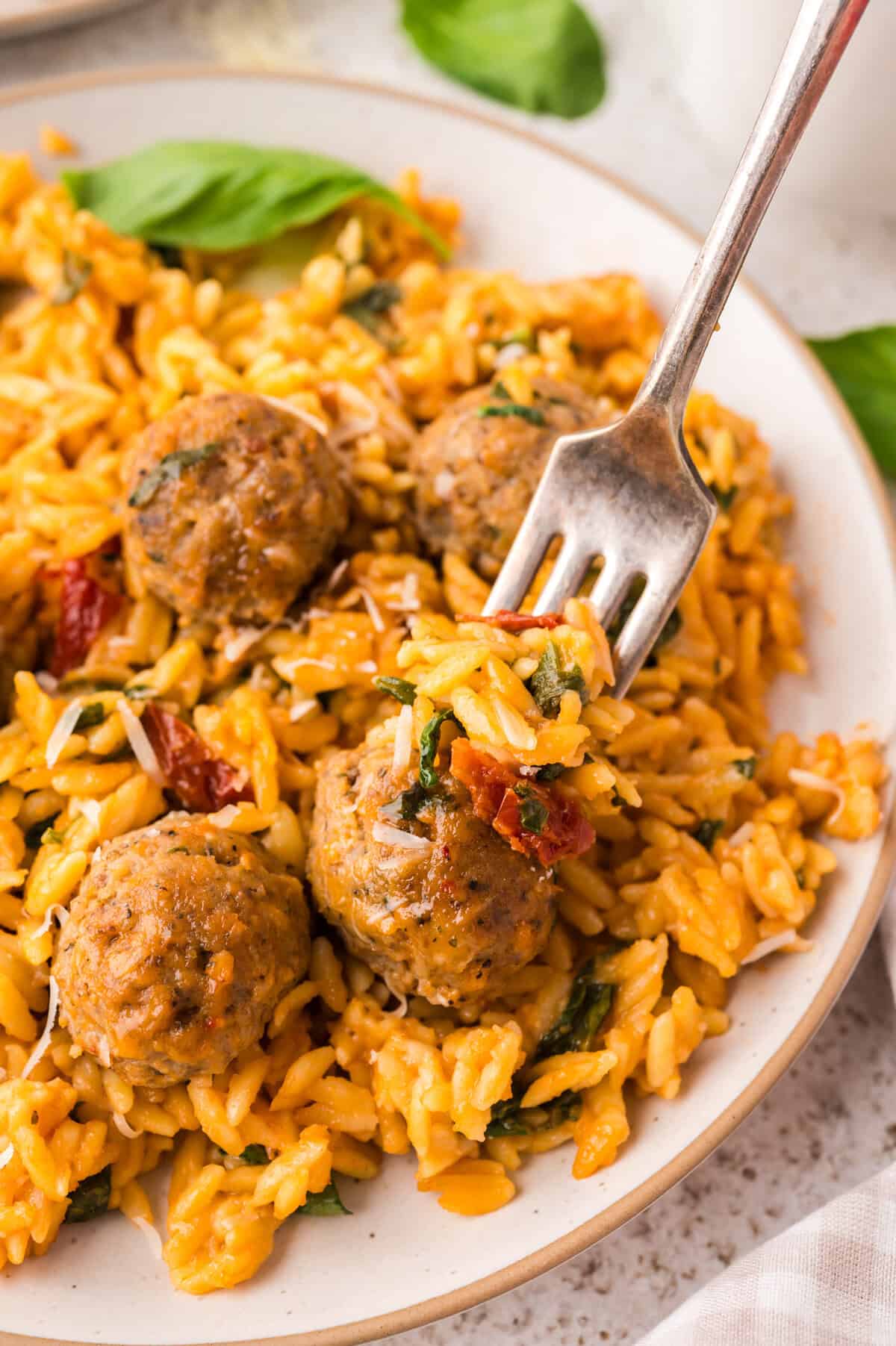 Baked orzo on plate with meatballs.