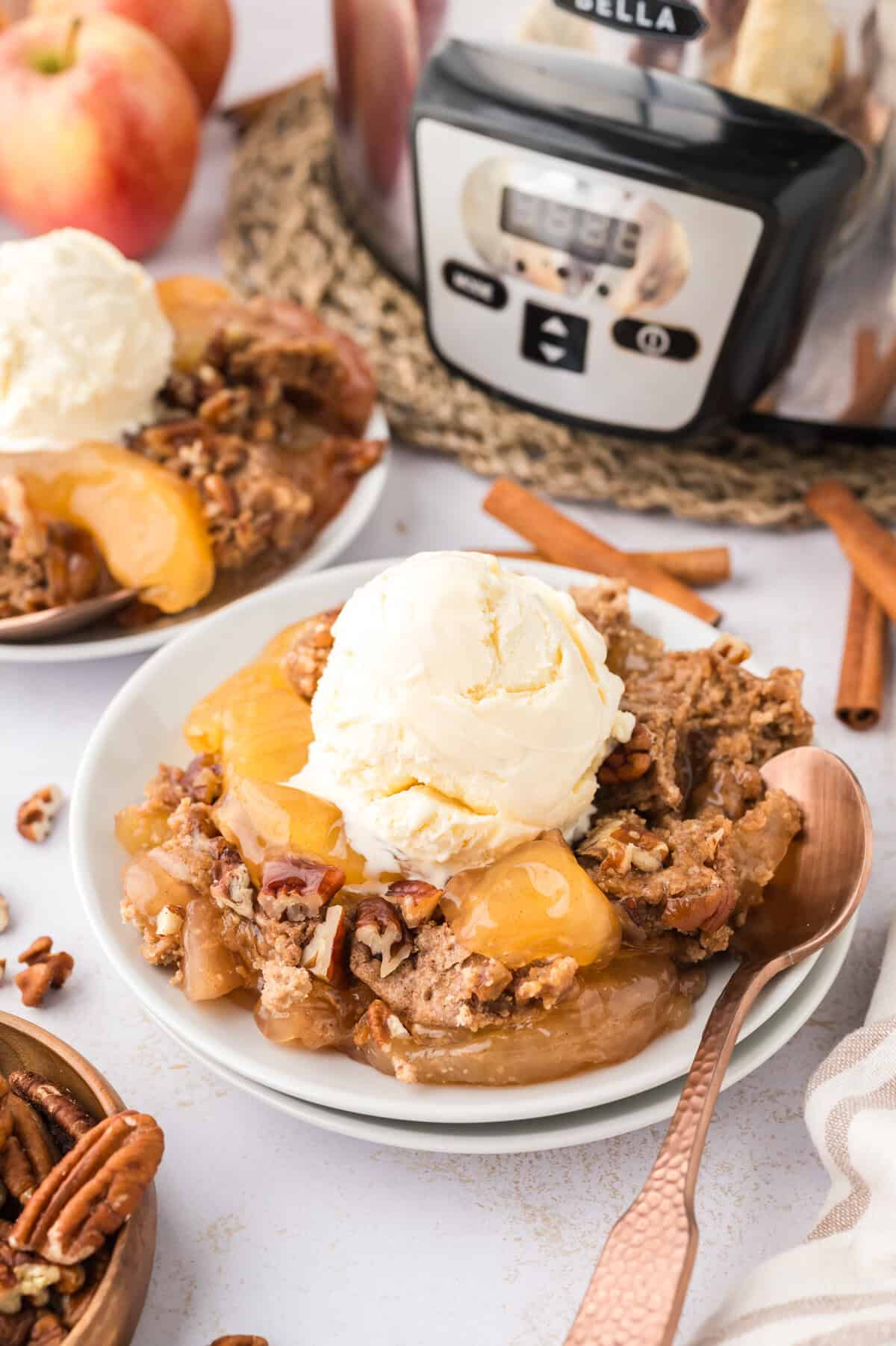 Plate full of crockpot apple dump cake topped with vanilla ice cream.