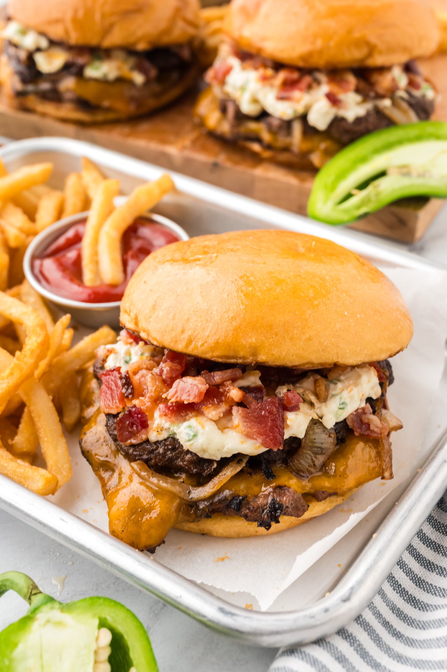 Jalapeno Smash Burgers on tray with fries.