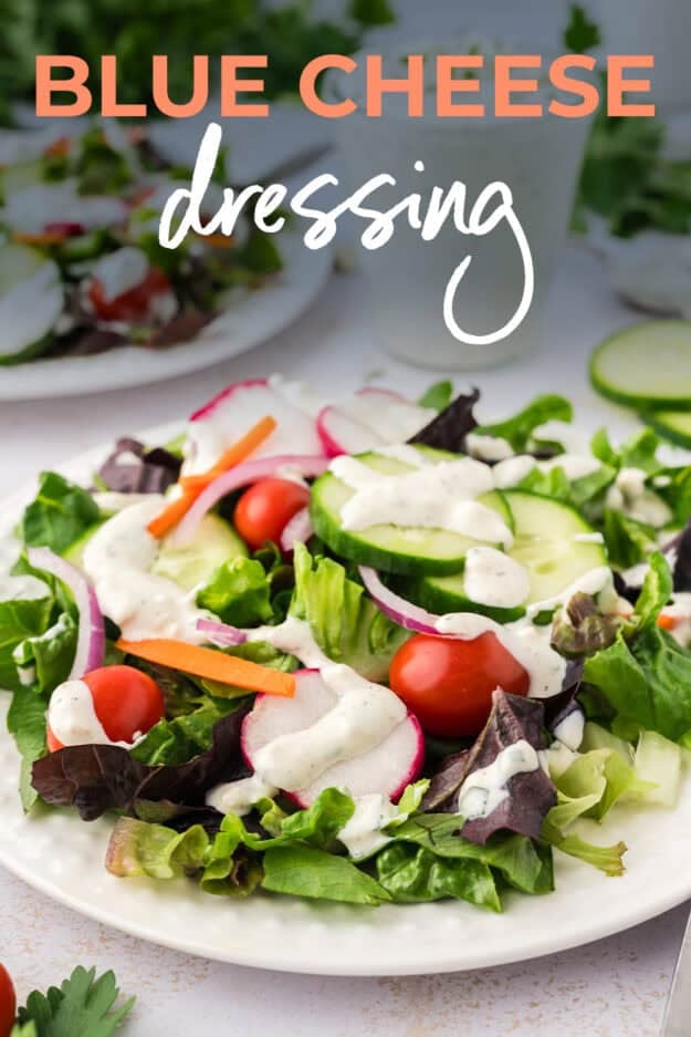 Plate full of salad greens topped with blue cheese dressing.