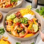 Chicken fajita bowls topped with cheese and gucamole.