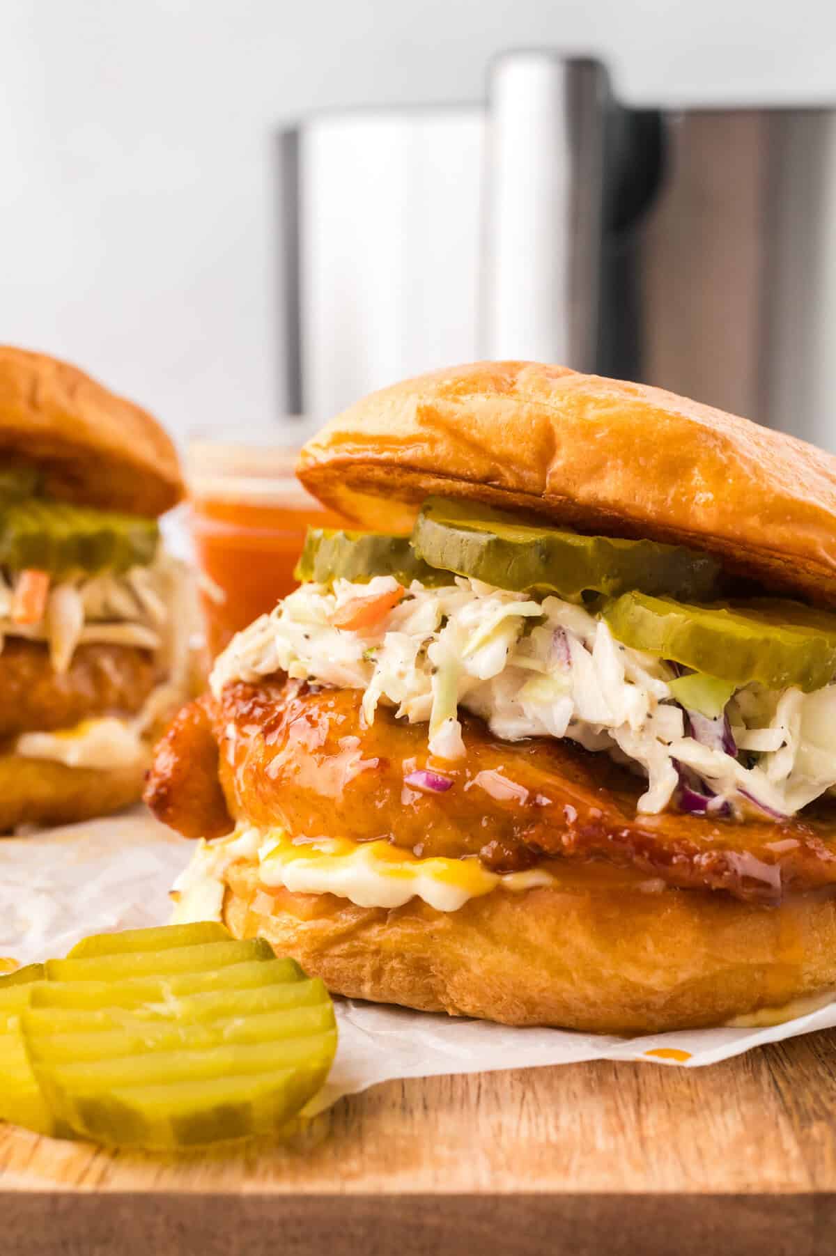 Hot honey chicken sandwich topped with slaw and pickles.