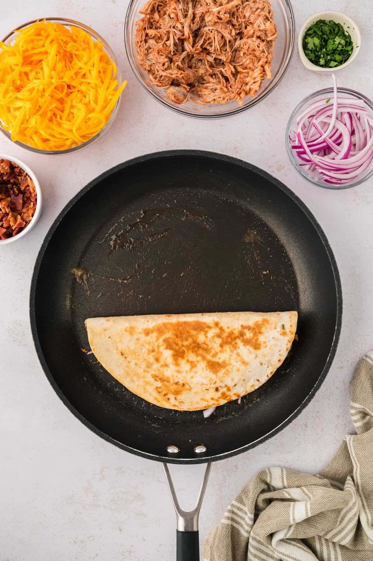 Quesadilla cooking in skillet.