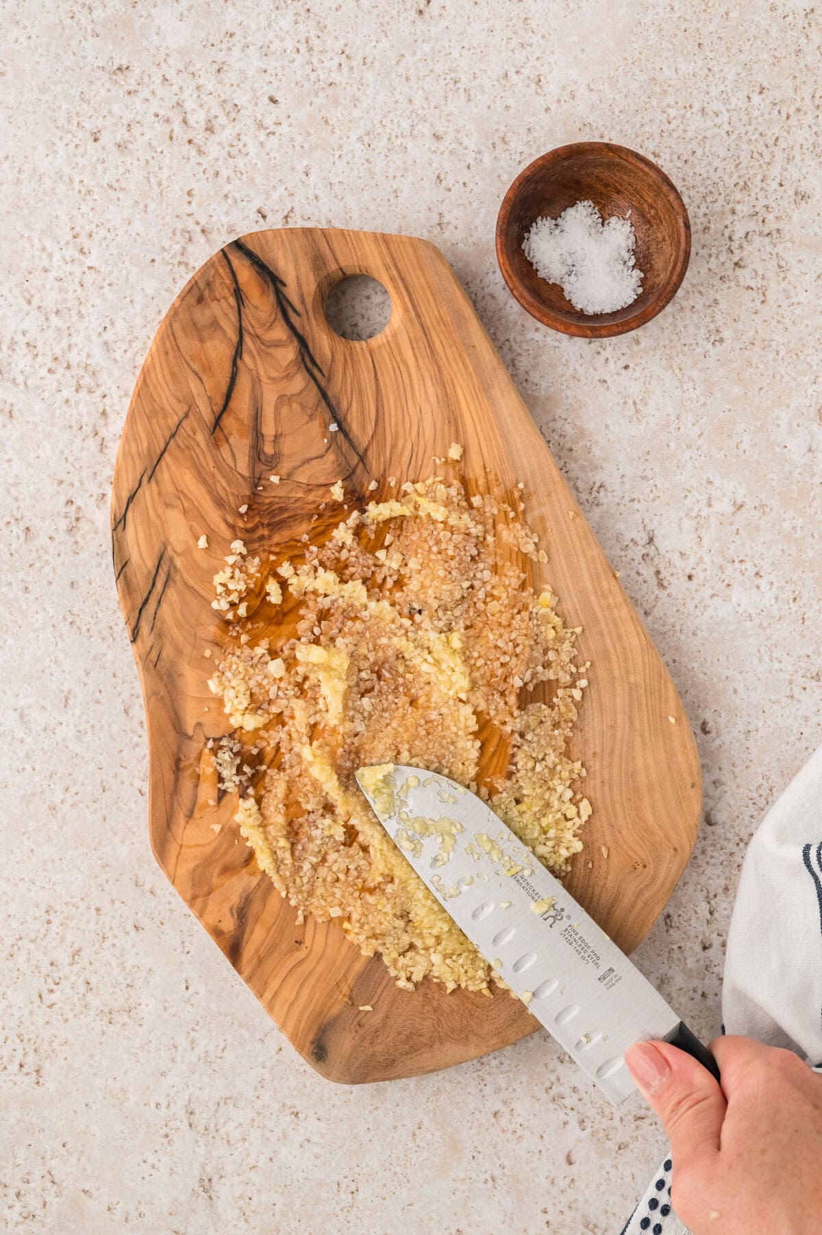 Using a knife to make garlic paste.