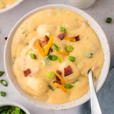 Bowl full of loaded gnocchi soup recipe topped with cheese and bacon.