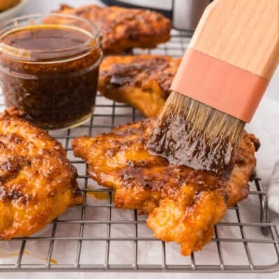 Chicken being brushed with Nashville hot sauce.