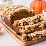 Sliced loaf of pumpkin streusel bread on cutting board.